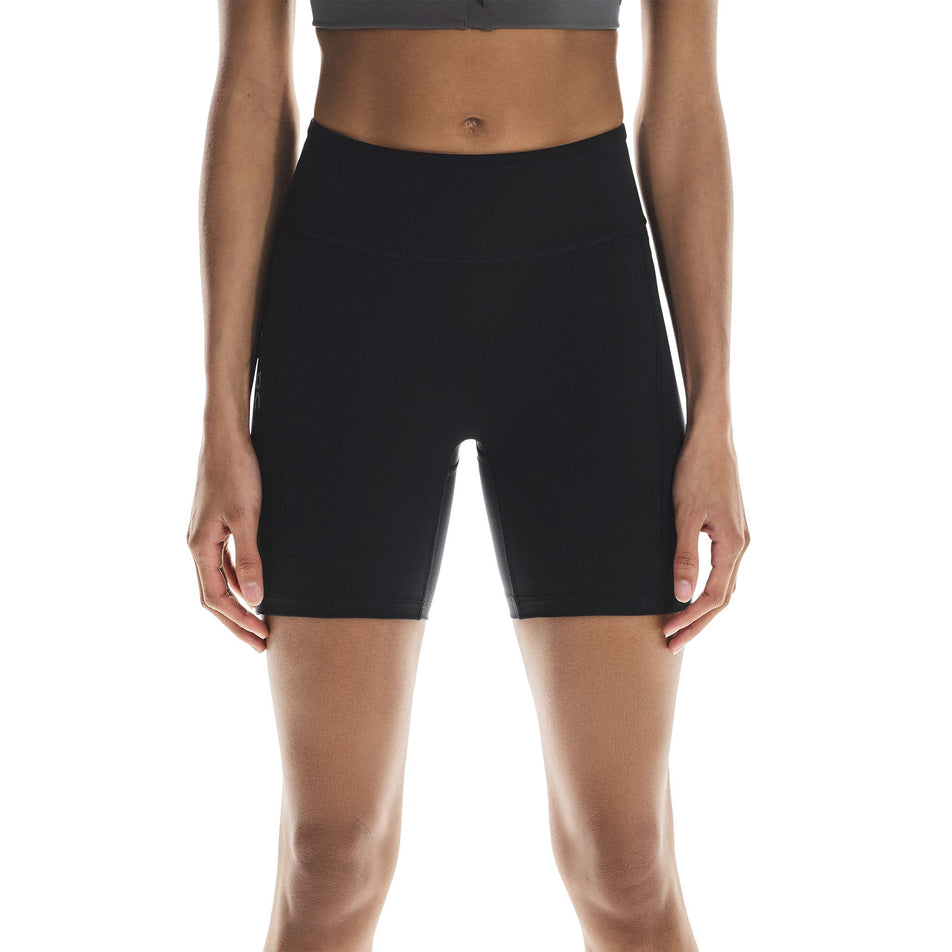 Front view of a model wearing the On Women's Performance Tights Short in the Black colourway. (8715718197410)