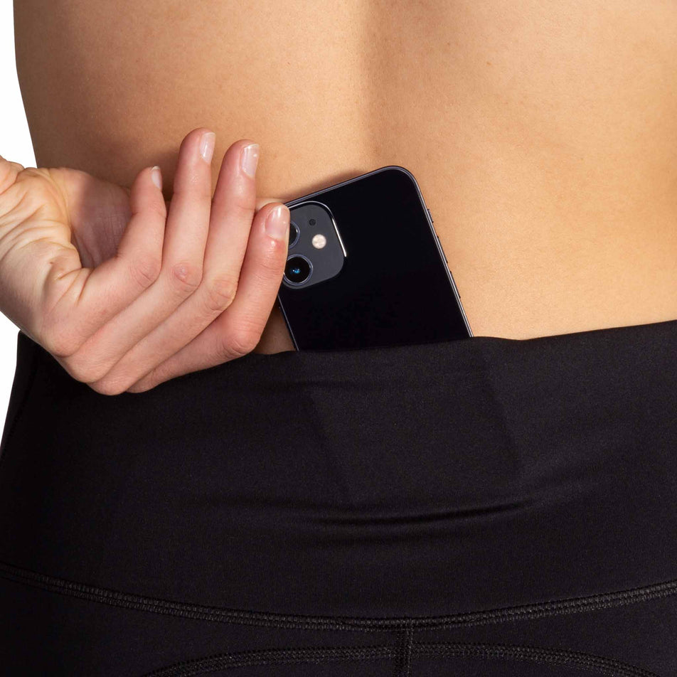 A model demonstrating the drop-in pocket at the back of the Brooks Women's Spark 8