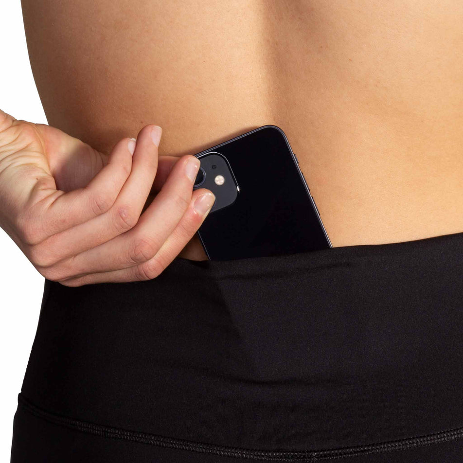 A model demonstrating the pocket at the back of the Brooks Women's Spark Tight in the Black colourway. (8718911406242)