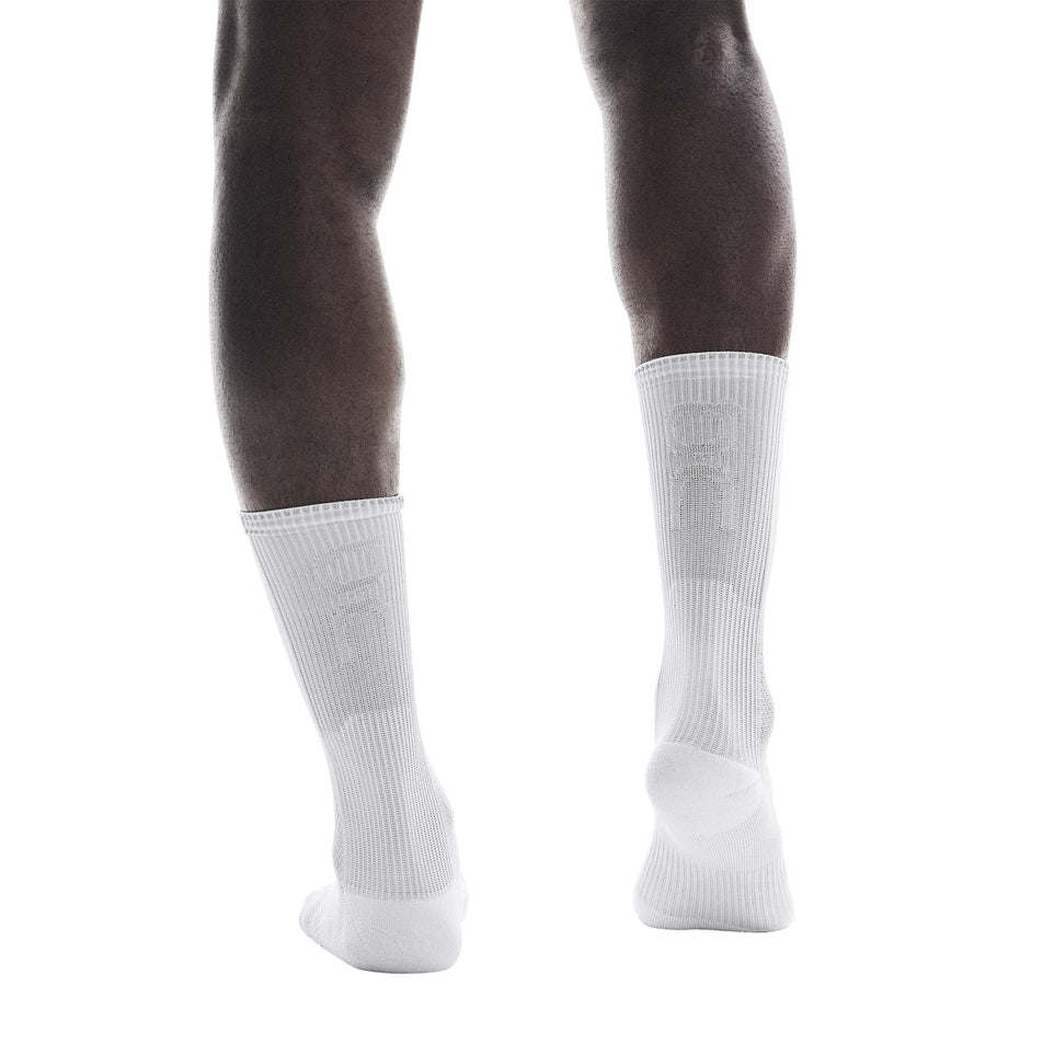 Back view of a model wearing a pair of On Unisex Performance Run Sock High in the White/Glacier colourway. (8717343522978)