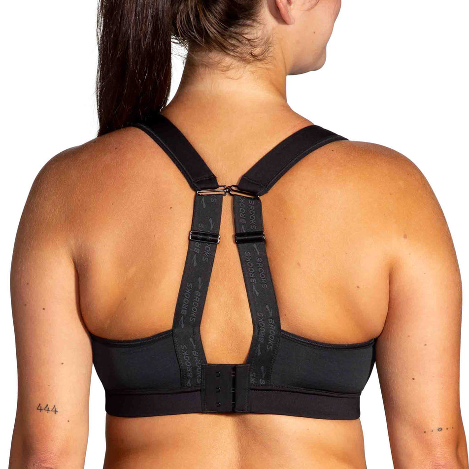 Back view of a model wearing the Brooks Women's Convertible 2.0 Sports Bra - demonstrating the racerback fit - in the Black colourway. (8636795551906)