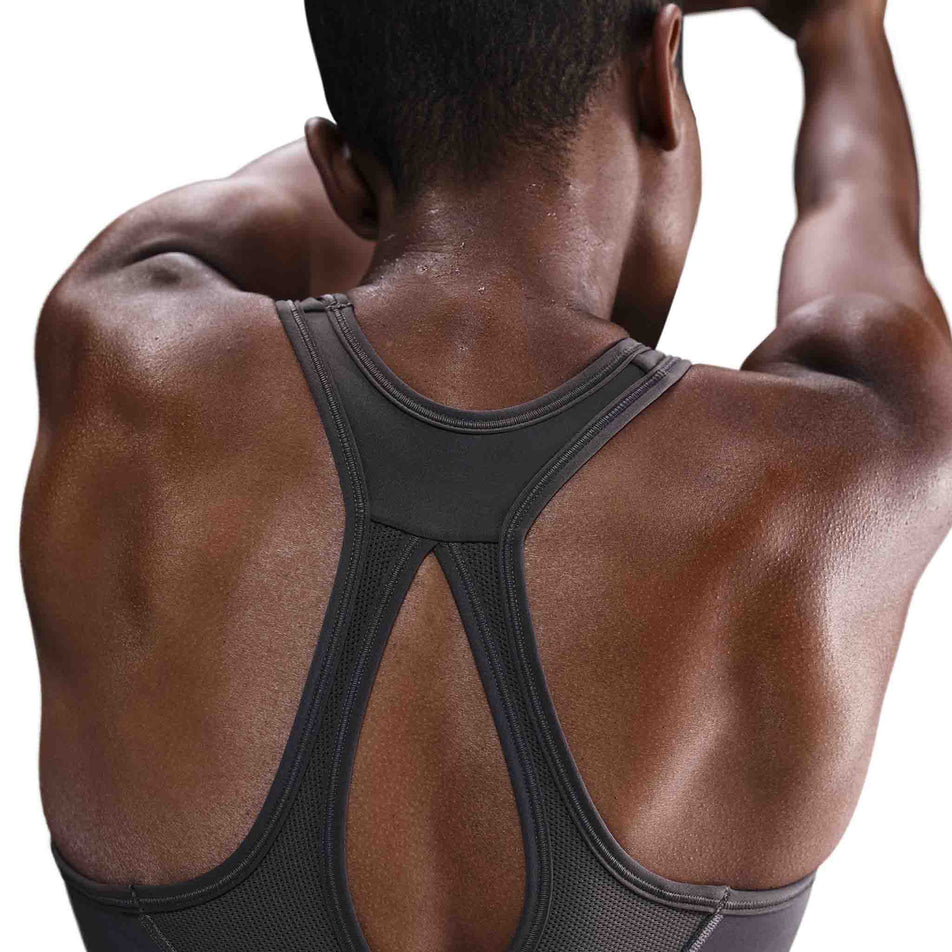 Back view of a model wearing the Nike Women's Swoosh High Support Non-Padded Adjustable Bra in the Thunder Grey colourway. (8692875165858)