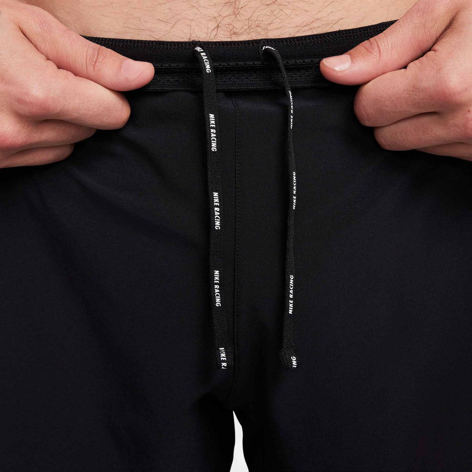 Front view of a model highlighting the drawcord on a pair of Nike Men's AeroSwift Dri-FIT ADV 4