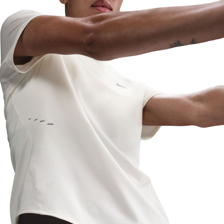 Front view of a model wearing the Nike Women's Swift Dri-FIT Short-Sleeve Running Top in the Sail/Reflective Silver colourway.(8692848984226)