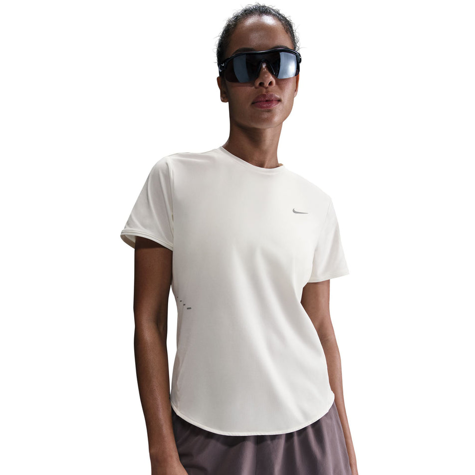 Front view of a model wearing the Nike Women's Swift Dri-FIT Short-Sleeve Running Top in the Sail/Reflective Silver colourway. (8692848984226)