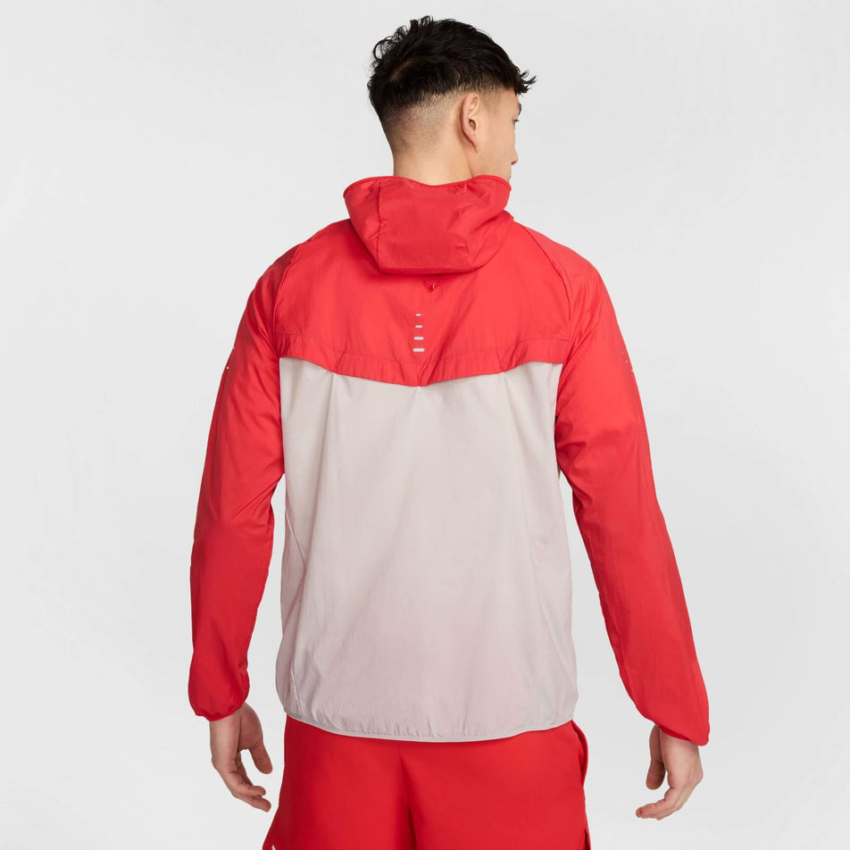 Back view of a model wearing a Nike Men's Stride Repel UV Running Jacket in the University Red/Reflective Silver colourway. Model is also wearing shorts. (8591132655778)