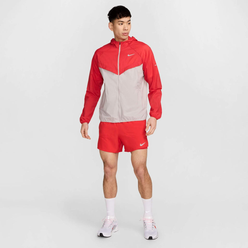 Front view of a model wearing a Nike Men's Stride Repel UV Running Jacket in the University Red/Reflective Silver colourway. Model is also wearing shorts, socks and shoes. (8591132655778)