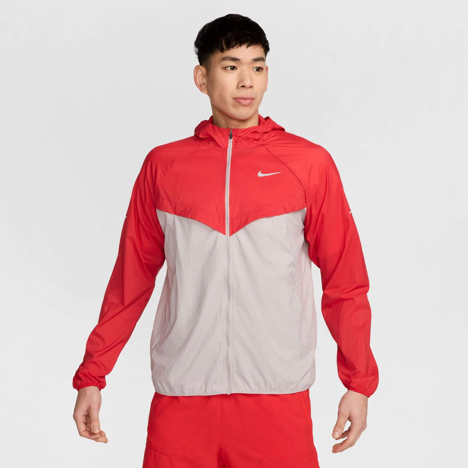 Front view of a model wearing a Nike Men's Stride Repel UV Running Jacket in the University Red/Reflective Silver colourway. Model is also wearing shorts. (8591132655778)