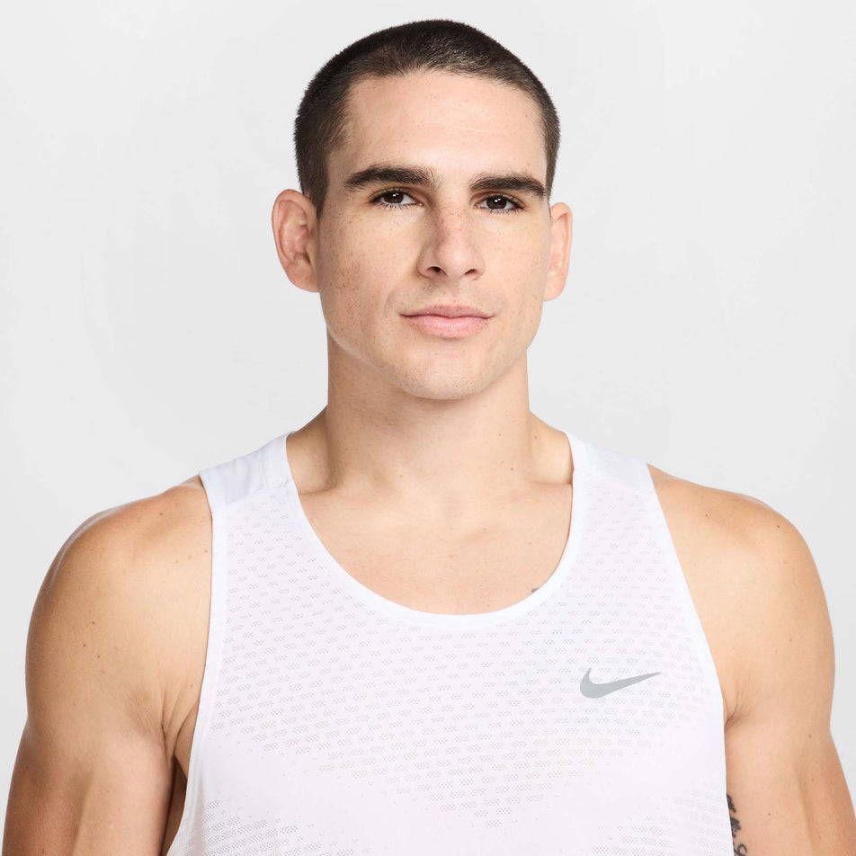 Front view of a model wearing the Nike Men's Stride Dri-FIT ADV Running Tank Top in the White/Reflective Silver colourway. (8620702433442)