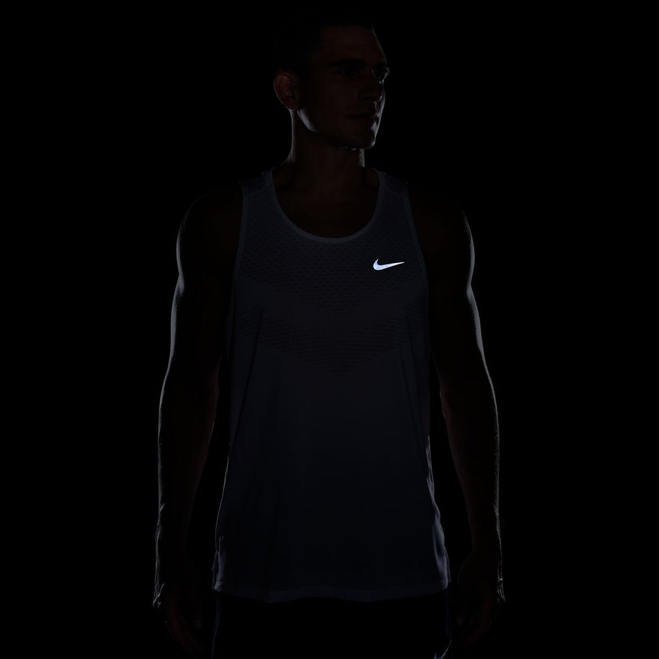 The reflective swoosh on the front of the Nike Men's Stride Dri-FIT ADV Running Tank Top in the White/Reflective Silver colourway. (8620702433442)
