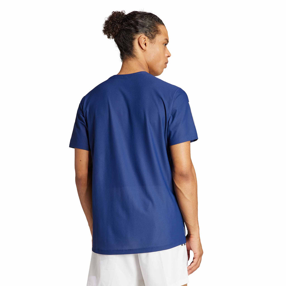 Back view of a model wearing an adidas Men's Own The Run T-Shirt in the Dark Blue colourway. Model is also wearing adidas legwear. (8449482588322)