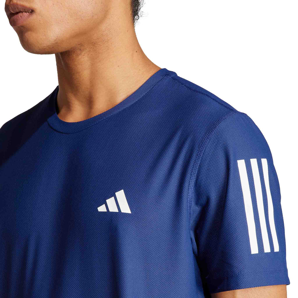 Close-up of the upper left-chest and upper left-arm section of an adidas Men's Own The Run T-Shirt in the Dark Blue colourway. Top is being worn by a model. (8449482588322)