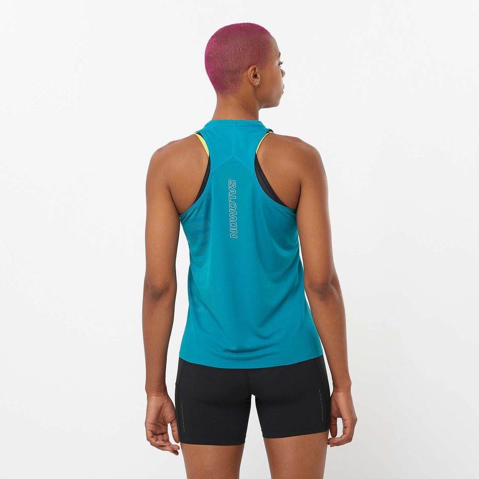 Back view of a model wearing a Salomon Women's Sense Aero GFX Singlet in the Tahitian Tide/Peacock Blue colourway. Model is also wearing Salomon running shorts. (8157872914594)