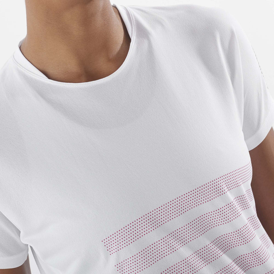 Close-up front view of a model wearing a Salomon Women's Sense Aero GFX Short Sleeve Tee in the White/Beetroot Purple colourway.  (8157870850210)