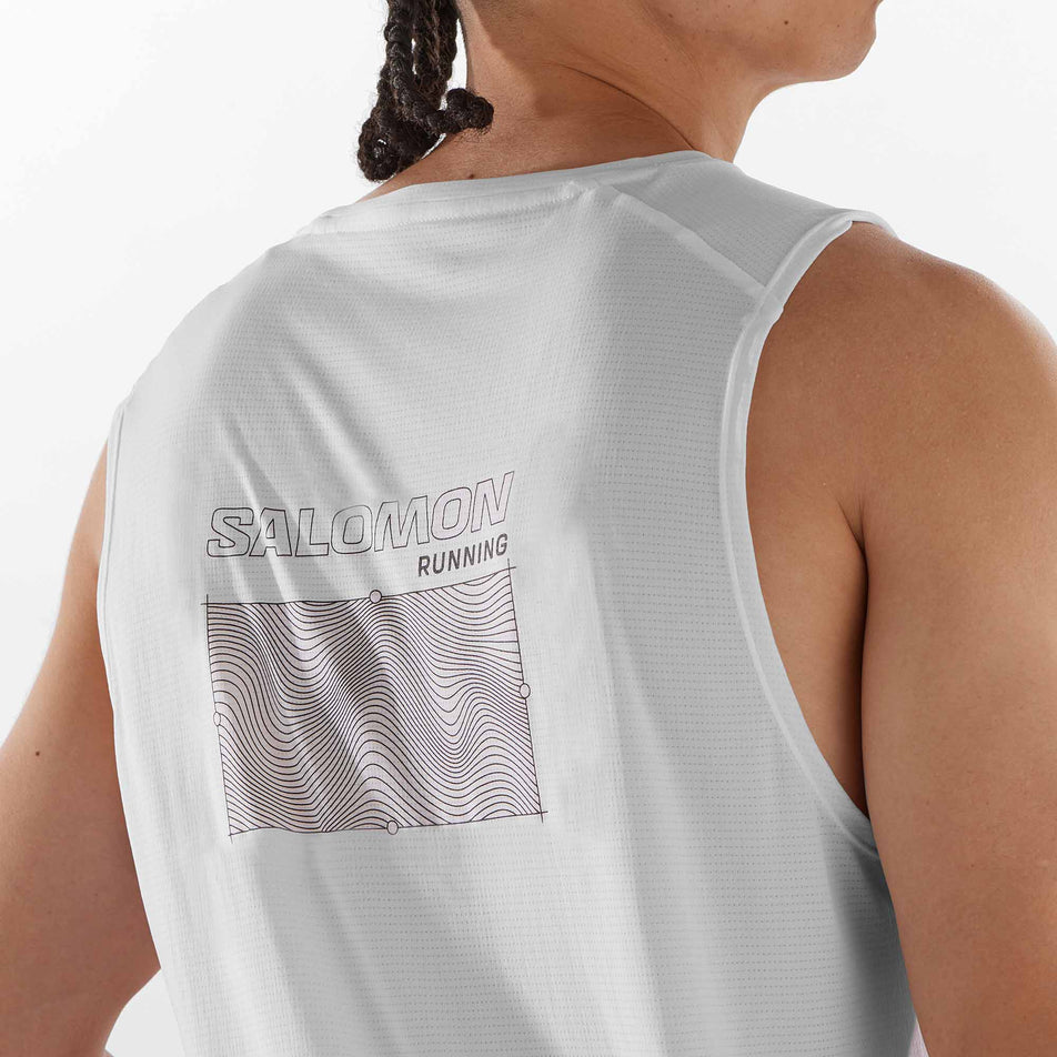 Close-up view of the graphic on the back of a Salomon Men's Cross Run Tank GFX in the White colourway. Top is being worn by a model. (8246399729826)