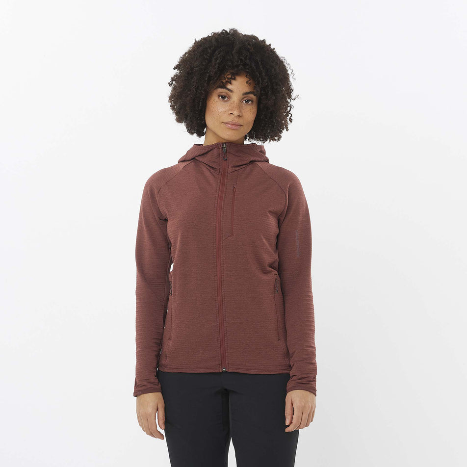 Front view of a model wearing the Salomon Women's Essential Lightwarm Midlayer Jacket Hoodie in the Rum Raisin colourway. Model is also wearing leggings. (8509527097506)
