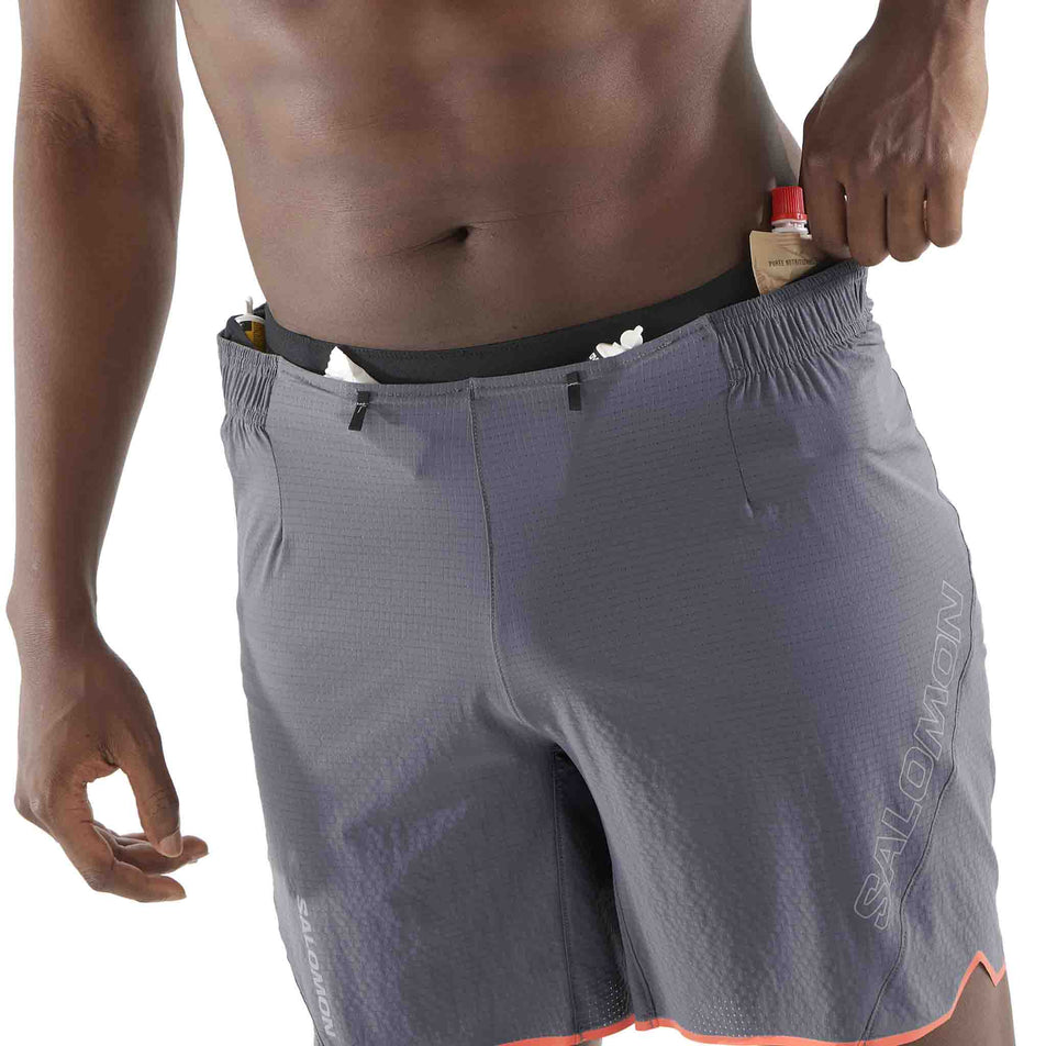 Front view of a model demonstrating the storage options on the front of the Salomon Men's Sense Aero 7