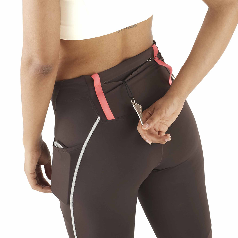 Back view of a model demonstrating the key loop in the zip back pocket on the Salomon Women's Sense Aero Stow Tights in the Coffee Bean colourway. (8574546084002)
