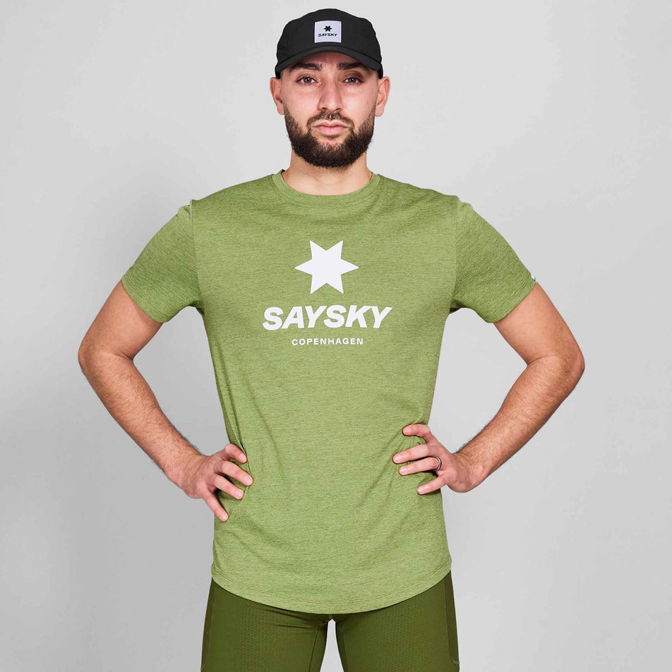 Front view of a model wearing a SAYSKY Men's Logo Combat Pro T-Shirt in the Green Melange colourway. Model is also wearing shorts and a cap. (8644805755042)