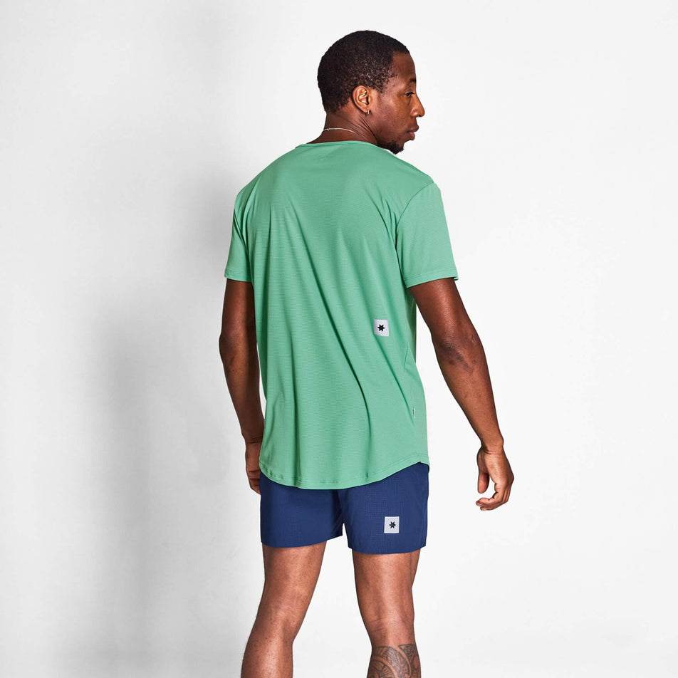 Back view of a model wearing a SAYSKY Men's Reactive Flow T-Shirt in the Green AOP colourway. Model is also wearing shorts. (8628407533730)
