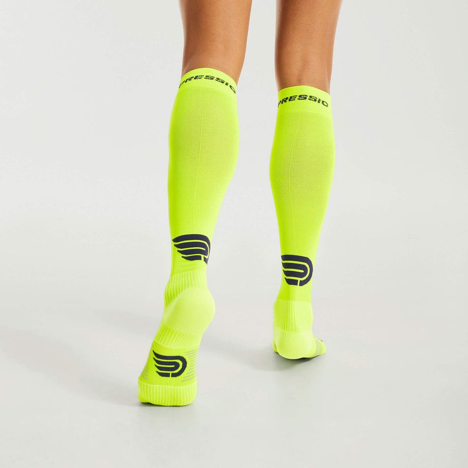 Back view of a model wearing the Pressio Unisex EQ Compression Socks in the Yellow/Navy colourway. (8341599781026)