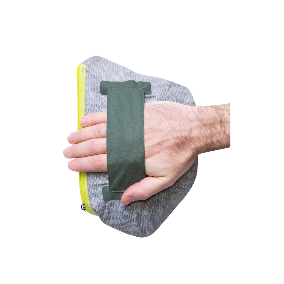 A model demonstrating that, once a Ronhill Men's Tech Fortify Jacket has been packed into its chest pocket, it can be carried in your hand - with the help of a strap. (8470624895138)