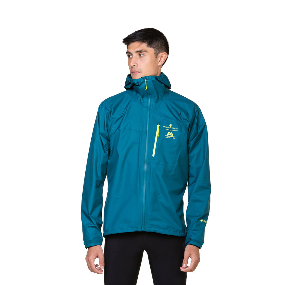 Front view of a model wearing a Ronhill Men's Tech GORE-TEX Mercurial Jacket in the Deep Teal/Acid colourway. Model is also wearing leggings. (8470598418594)