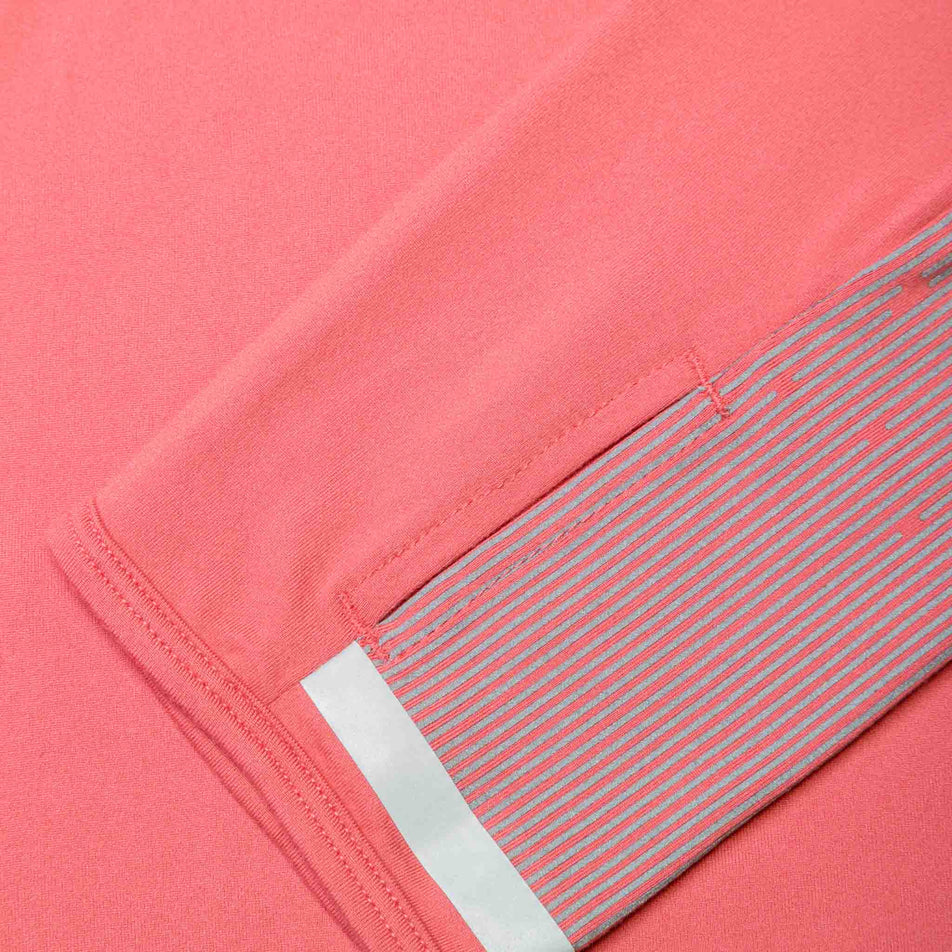 Close-up of the reflective details on the sleeve of a Ronhill Women's Tech Reflect 1/2 Zip in the Salsa/Reflect colourway. (8469213249698)