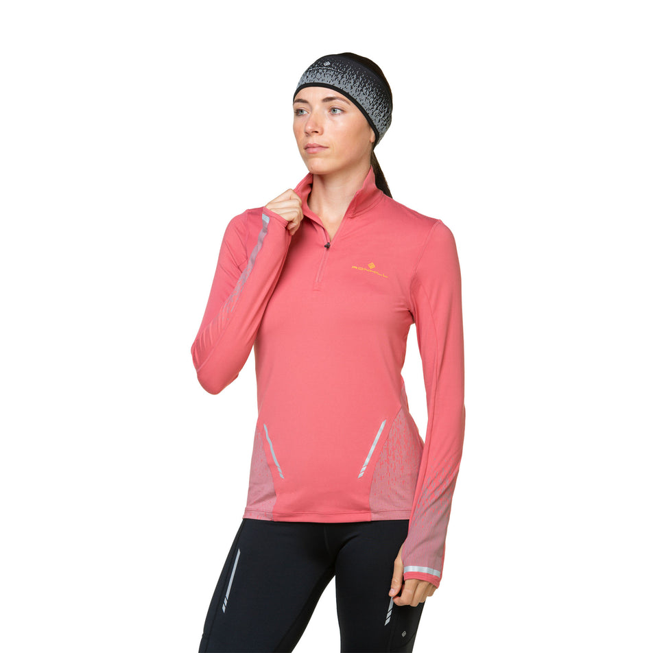 Front view of a model wearing a Ronhill Women's Tech Reflect 1/2 Zip in the Salsa/Reflect colourway. Model is also wearing leggings and a headband. (8469213249698)