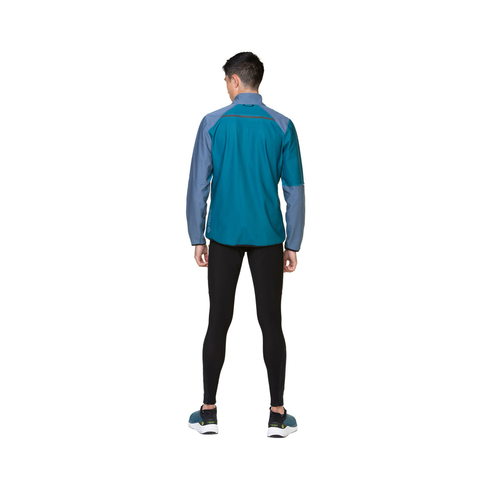 Back view of a model wearing a Ronhill Men's Tech GORE-TEX Windstopper Jacket in the Deep Teal/Lake Acid colourway. Model is also wearing tights, socks and shoes. (8470614016162)
