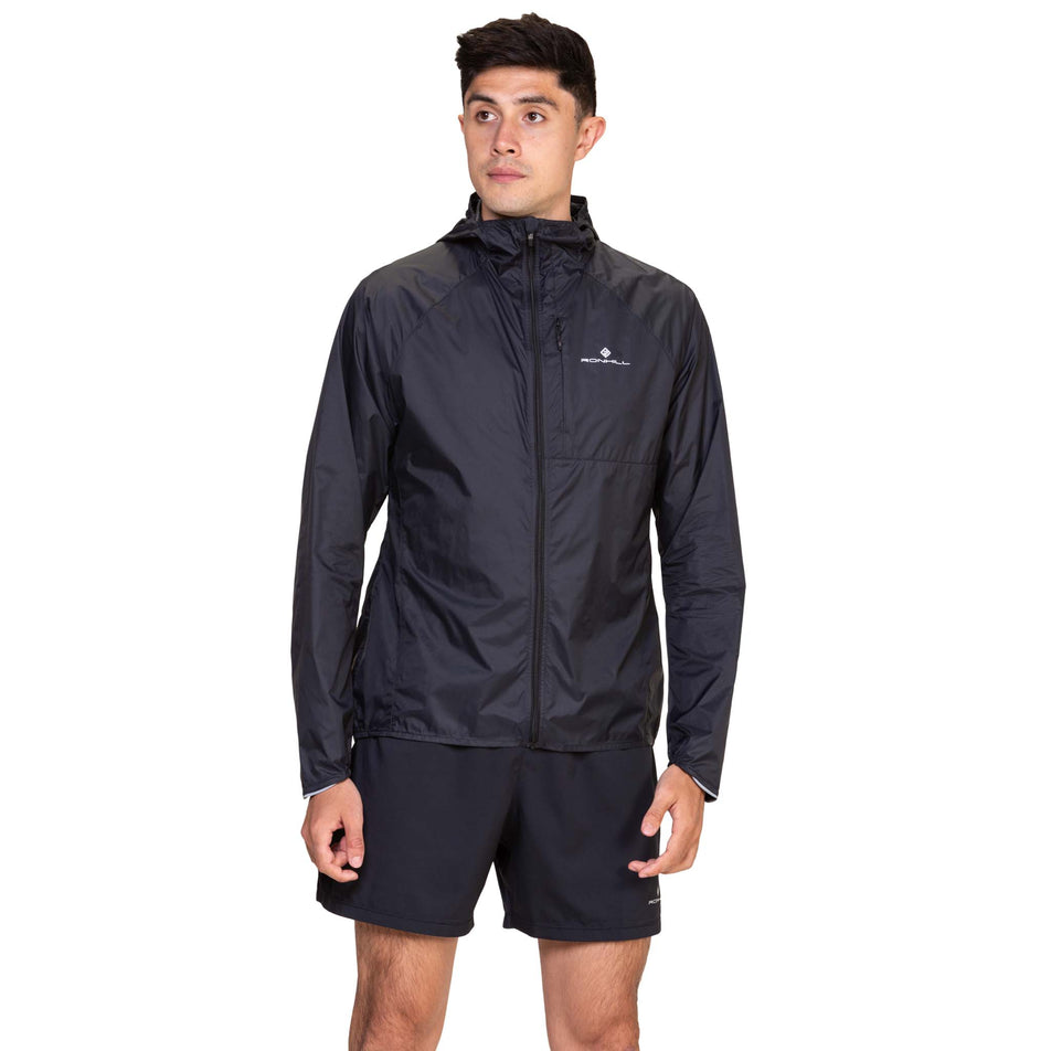 Front view of a model wearing the Ronhill Men's Tech All-Terrain Jacket in the All Black colourway. (8563617431714)